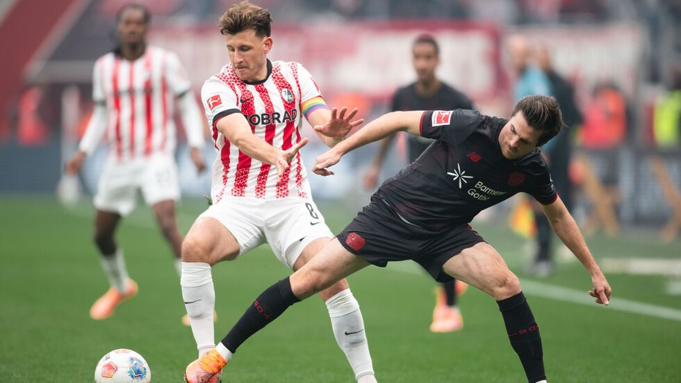 Freiburgs Maximilian Eggestein (l) und Leverkusens Jonas Hofmann im Zweikampf. 