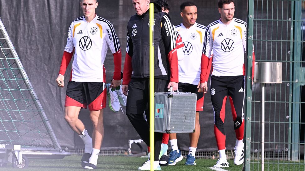 Mit Teamarzt Hahne (2.v.l.) betritt Schlotterbeck (l.) den Trainingsplatz. 