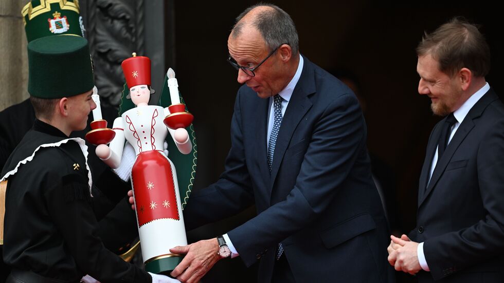 Bundeskanzler Friedrich Merz (CDU) erhält neben Ministerpräsident Michael Kretschmer (CDU, r) bei seiner Ankunft vor der Staatskanzlei eine erzgebirgische Engelsfigur. Bundeskanzler Friedrich Merz (CDU) erhält neben Ministerpräsident Michael Kretschmer (CDU, r) bei seiner Ankunft vor der Staatskanzlei eine erzgebirgische Engelsfigur.