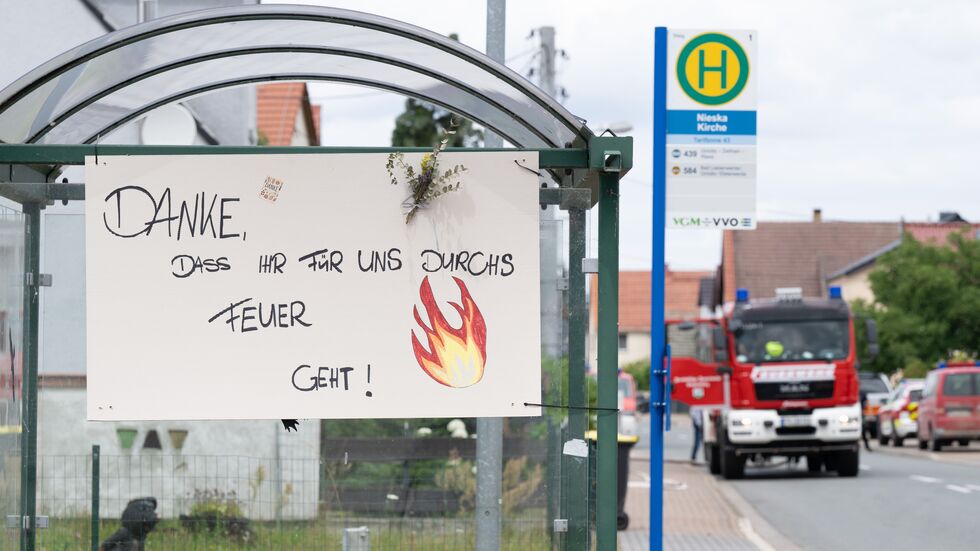 Ein Schild mit der Aufschrift „Danke, dass ihr für uns durchs Feuer geht“ hängt während des Waldbrands in der Gohrischheide an einer Haltestelle in Nieska.