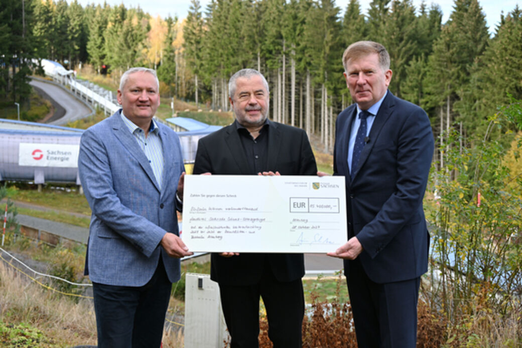 v.l.n.r.: Geschäftsführer Jens Morgenstern (Wintersport Altenberg (Osterzgebirge) GmbH, Landrat Michael Geisler (Landkreis Sächsische Schweiz-Osterzgebirge) und Staatssekretär Dr. Frank Pfeil (Sächsisches Staatsministerium des Innern) mit dem Fördermittelbescheid zur Modernisierung der Rennschlitten- und Bobbahn