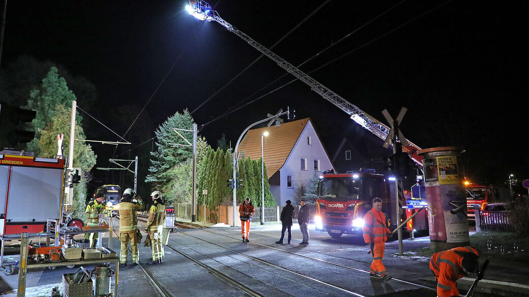 Die Feuerwehr steht bei den Straßenbahngleisen.