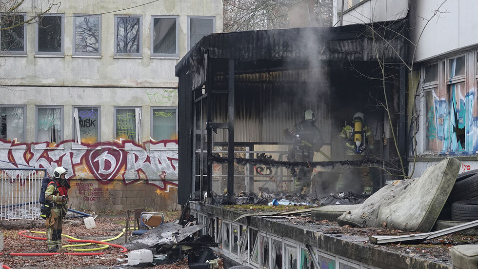 Feuerwehrleute löschen den Brand in dem verfallenen Gebäude Feuerwehrleute löschen den Brand in dem verfallenen Gebäude