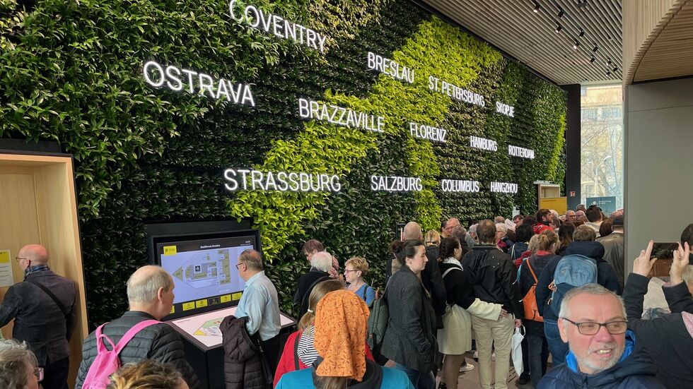 An einer grünen Wand aus Pflanzen leuchten Dresdens Partnerstädte