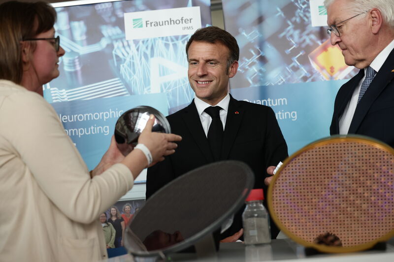 Steinmeier (r.) und Emmanuel Macron lassen sich während ihres Besuches im Fraunhofer-Institut für Photonische Mikrosysteme (IPMS), die Funktionsweise der sogenannten "Wafer" erklären.