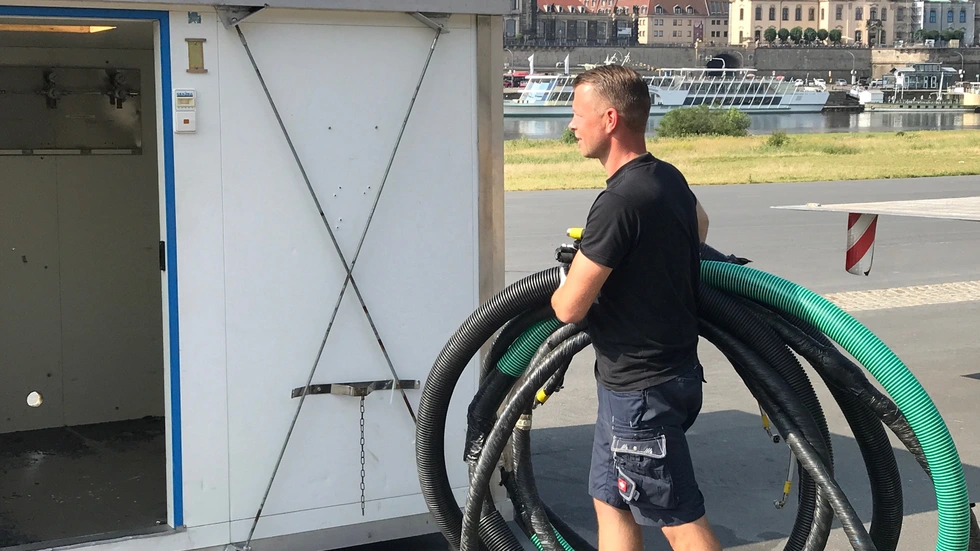 Martin Landeck von Radeberger verlegt am Königsufer die Bierleitungen für die Filmnächte. Foto: Rocco Reichel