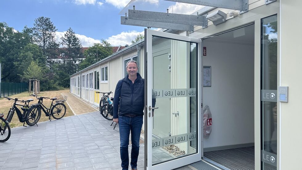 Bildungsbürgermeister Jan Donhauser am Eingang der Schul-Container, die für mehr Platz neben dem Gymnasium LEO aufgestellt wurden