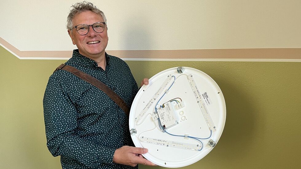 Rico Dietze vom Dresdner Schulamt zeigt eine neue LED-Leuchte, die in der Schule verbaut wird