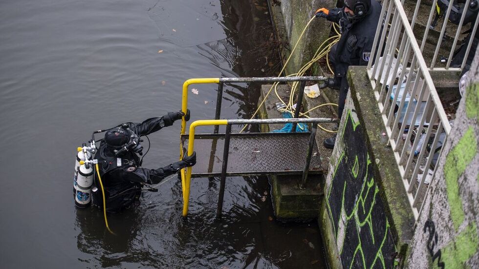 Ein Polizeitaucher steigt nach der Suche aus dem Schifffahrtskanal. Ein Polizeitaucher steigt nach der Suche aus dem Schifffahrtskanal.