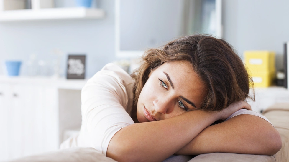 Frau nachdenklich, auf Tisch gestützt